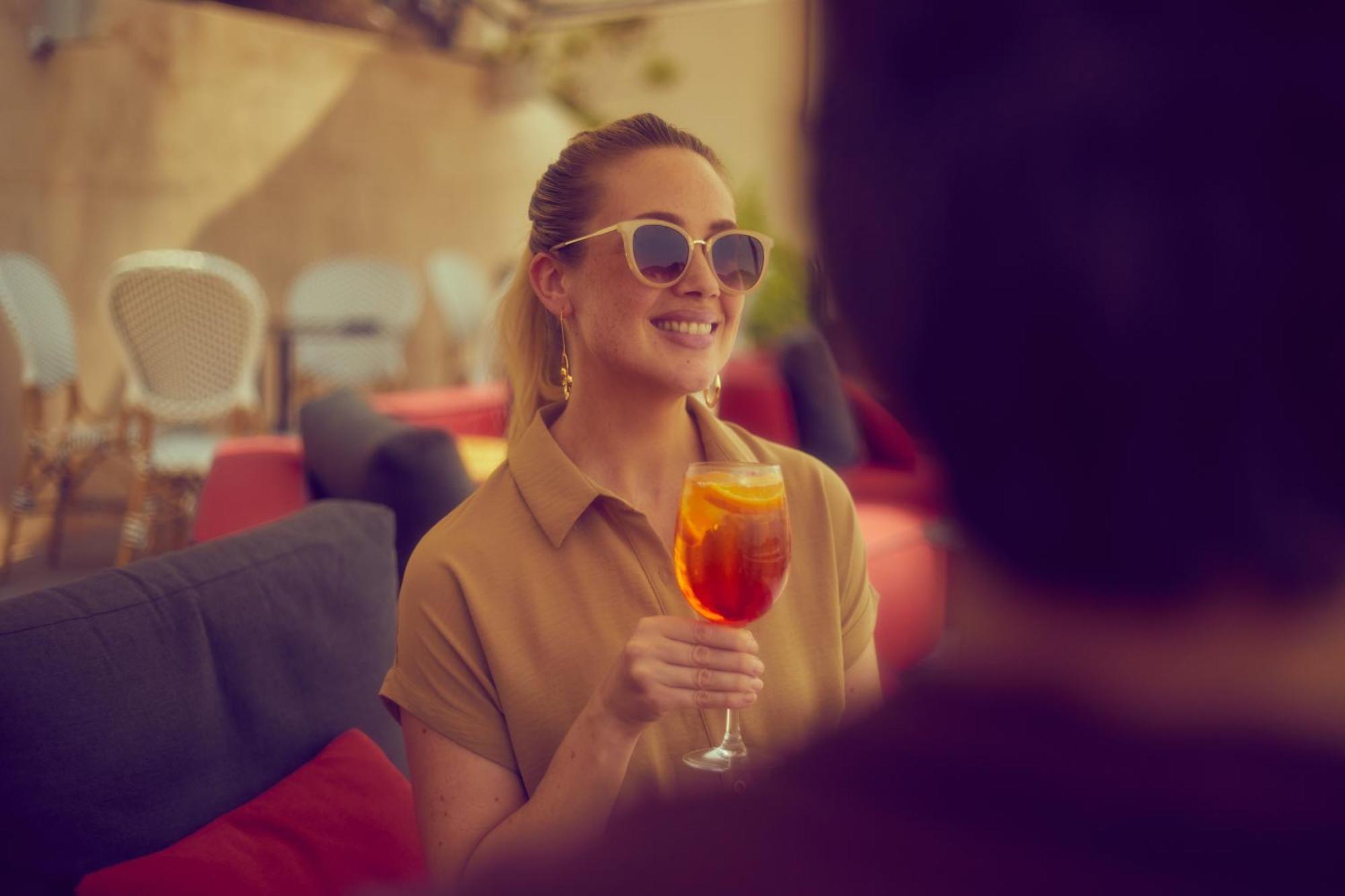 Secrets Mallorca Villamil Resort & Spa - Adults Only Peguera Exteriér fotografie A woman drinking an Aperol Spritz